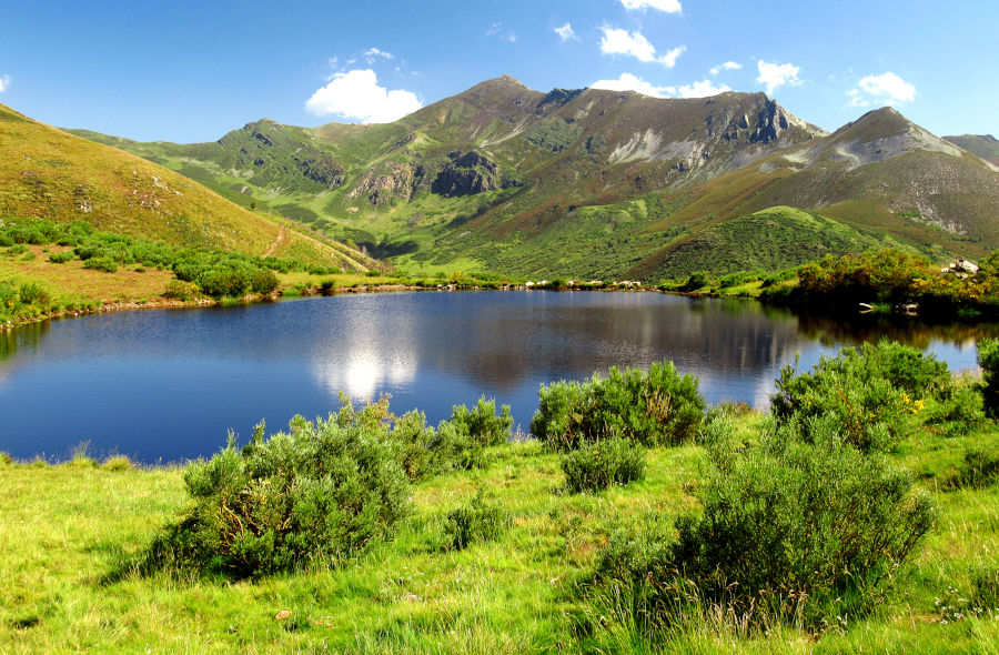 Una laguna en primer plano refleja como un espejo el macizo que tiene detrás